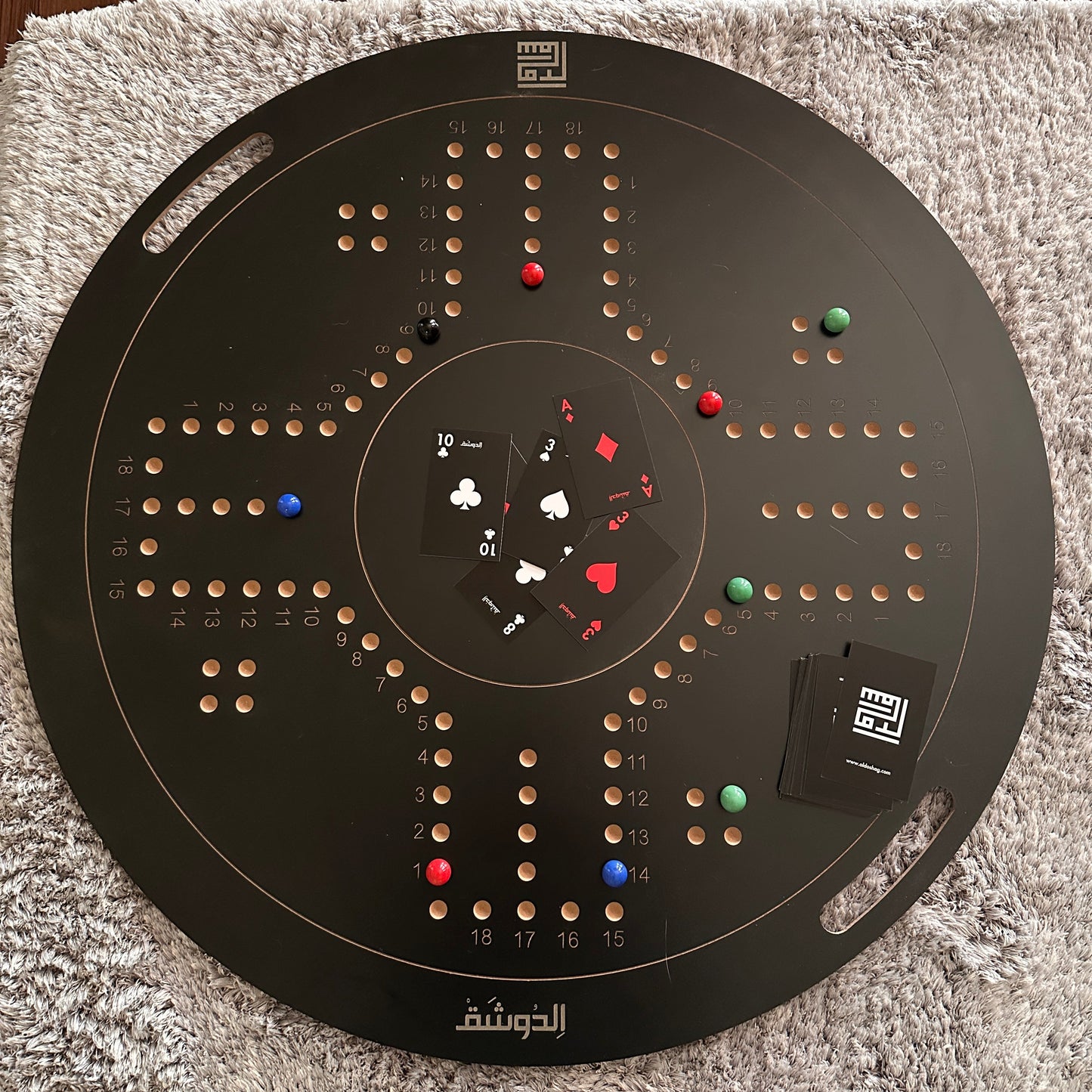 Circular black board with various colored markers on a textured surface