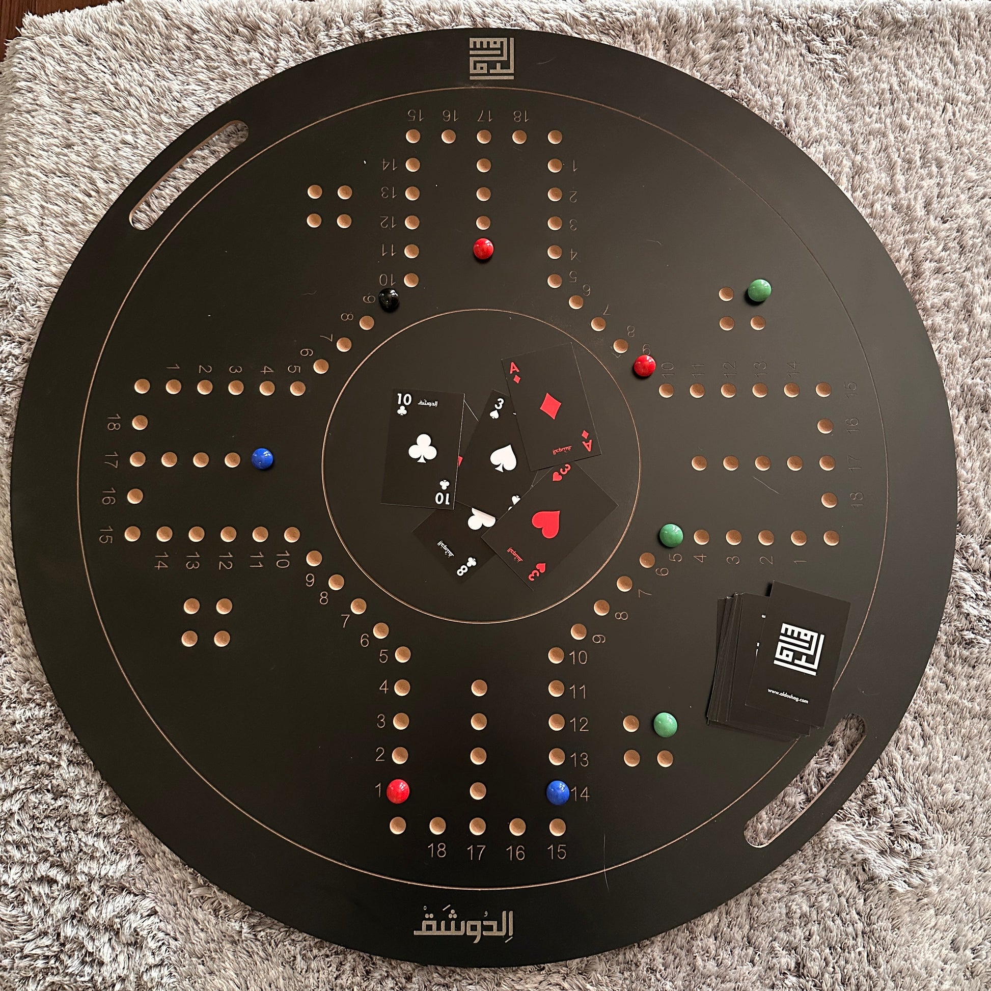Circular black board with various colored markers on a textured surface