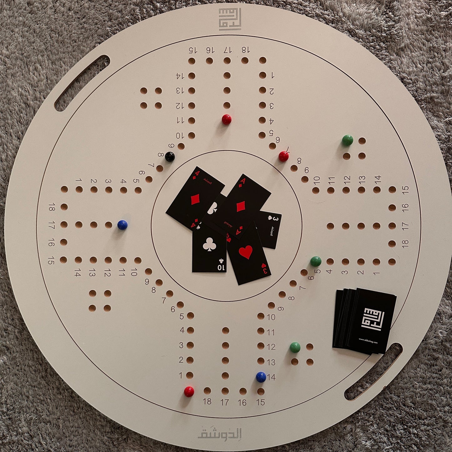 Circular board game with cards and markers on a textured surface